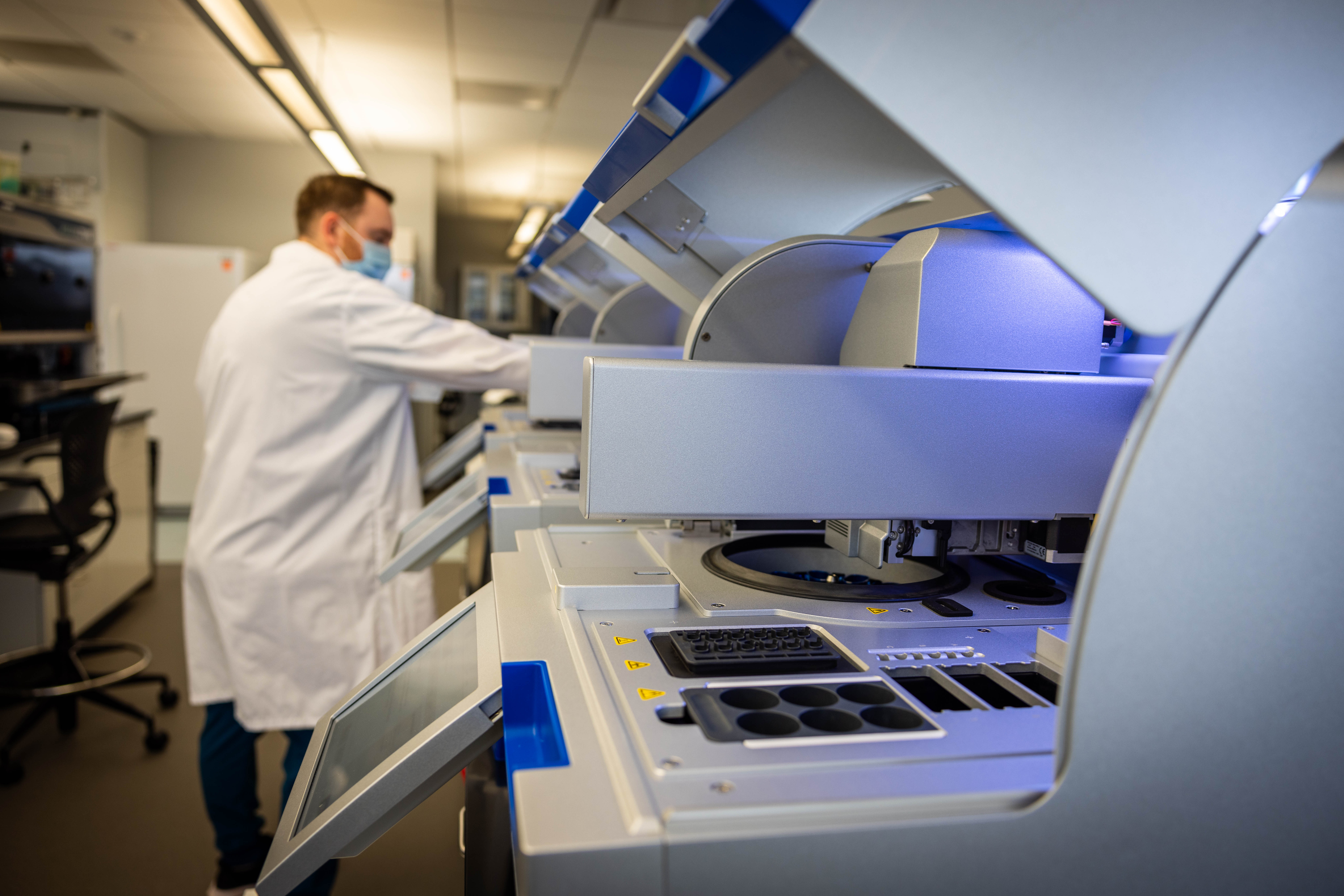 A scientist is putting some materials in a machine