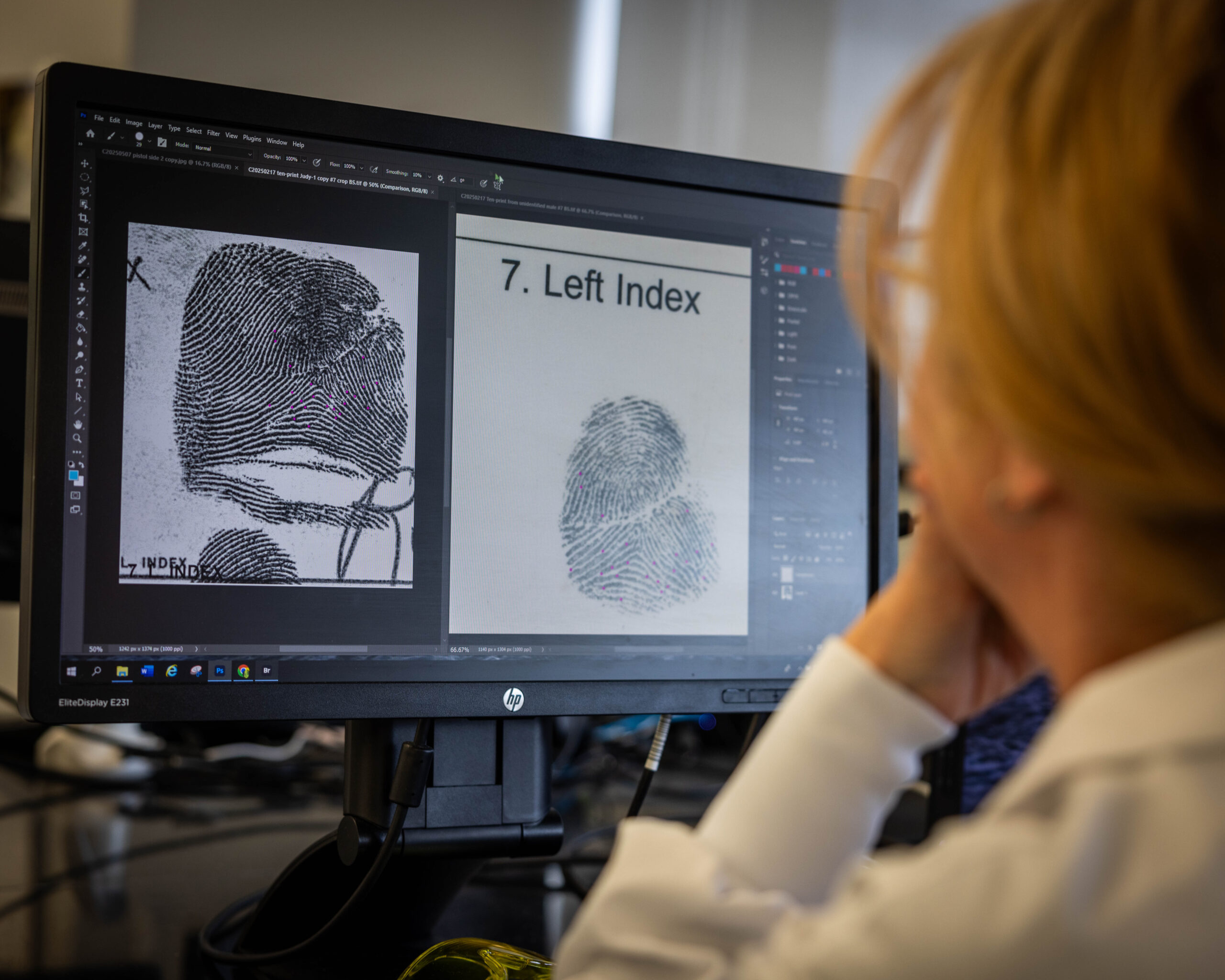 A fingerprint analyst looks at a computer screen