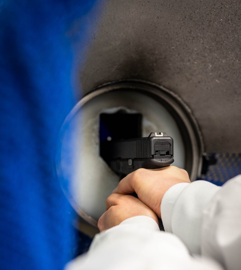 Close up of handgun being held and shot into the water tank