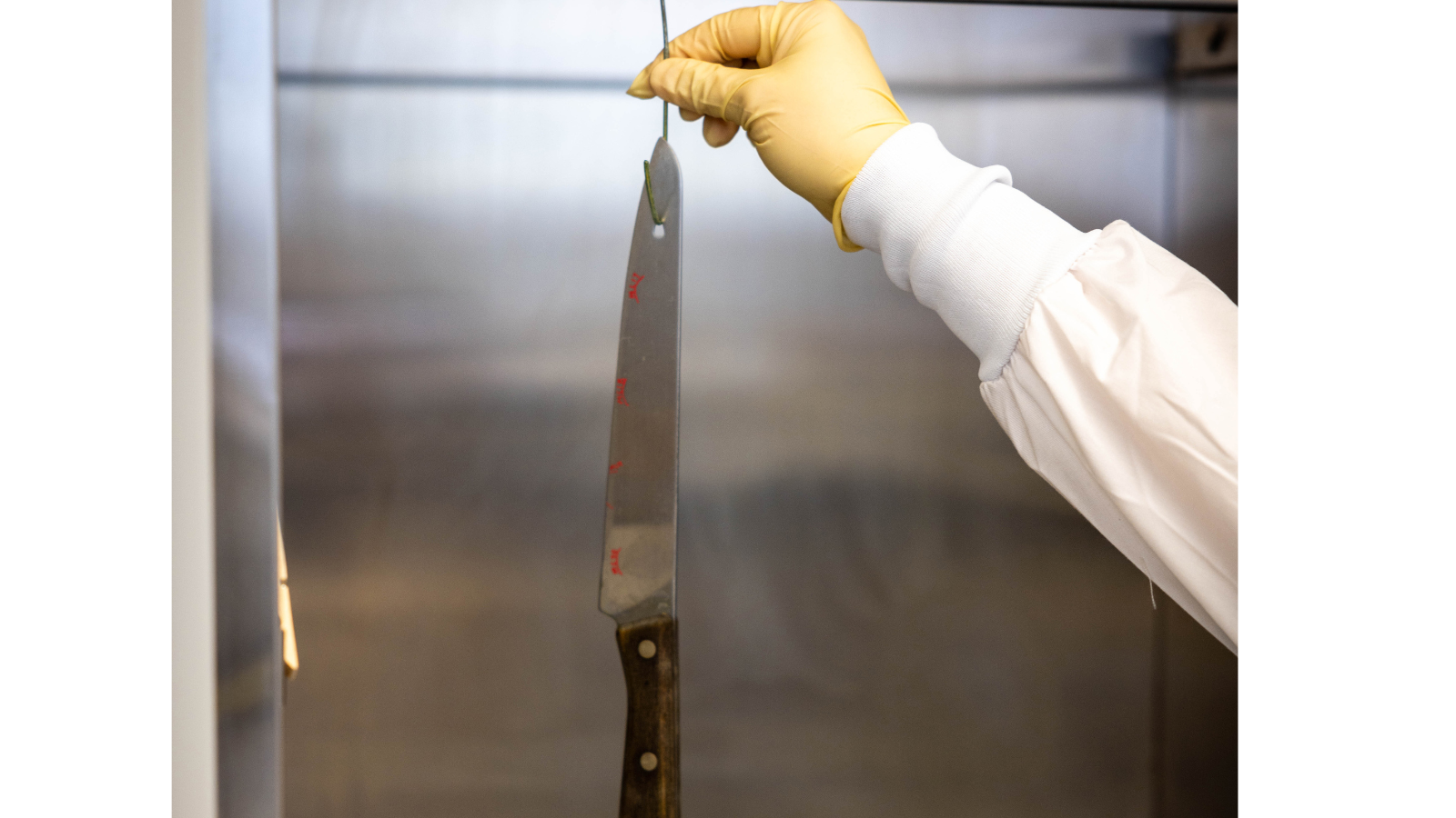 A fingerprint analyst hangs a knife in the lab